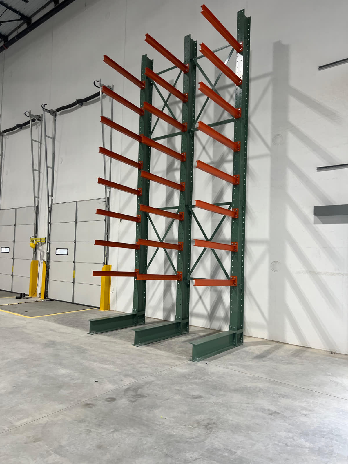 Cantilever rack arms mounted along a warehouse wall
